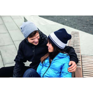 A fleece beanie in navy blue with a light grey band, worn by a man and a woman sitting together outdoors.