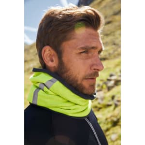 A bright yellow scarf with grey accents is worn around a man's neck against a natural backdrop.