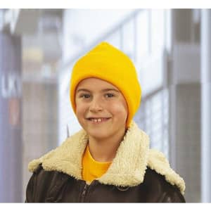 A yellow knitted beanie worn by a smiling child, paired with a brown jacket featuring a fluffy collar.