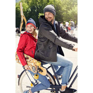 A man in a black jacket and beanie and a woman in a red jacket and beanie sit on a bicycle.
