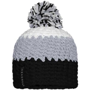 A knitted beanie featuring a pompon, in shades of grey, white, and black, with a logo tag.