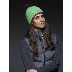 A green knitted hat with a purple pompon, worn by a woman with long hair, paired with a grey vest.