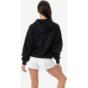 A black mineral wash fleece wide hoodie with a hood, worn with white shorts, showcasing a relaxed fit.