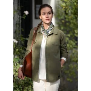 A unisex olive-green shirt with two front pockets, worn over a white top, paired with a patterned scarf and brown bag.