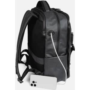 A black utility backpack with a charging cable and a smartphone at its base. It features a logo on the side.