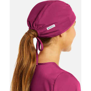A unisex scrub cap in a vibrant fuchsia colour, featuring a logo and a ponytail opening at the back.