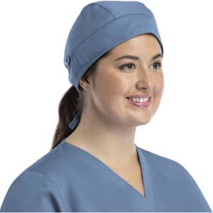 A unisex scrub cap in light blue with buttons, worn by a woman smiling, featuring a simple design and a logo.