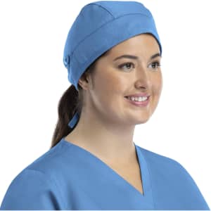 A unisex scrub cap in light blue with buttons, worn by a smiling woman.
