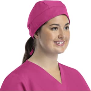 A pink unisex scrub cap with buttons displayed on a model, featuring a tied back design.