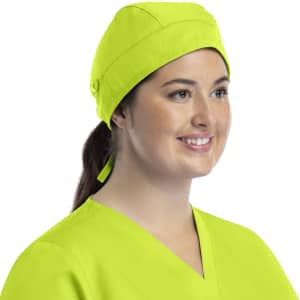 A unisex scrub cap in bright yellow with buttons, worn by a smiling woman with a ponytail.