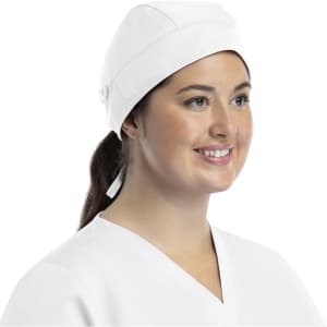 A white unisex scrub cap with buttons, modeled by a woman with long hair in a ponytail, smiling.