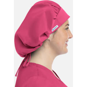 A unisex bouffant scrub cap in bright pink, featured on a model viewed from the side. It has a branding tag.