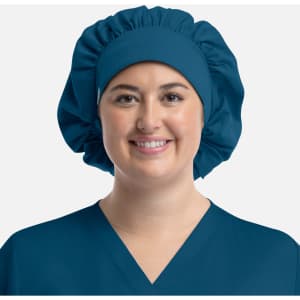 A unisex bouffant cap in teal, designed for uniforms, worn by a person smiling. The cap features a logo.