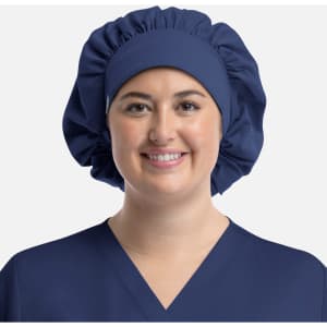A unisex bouffant scrub cap in navy blue, featuring a gathered design and worn by a model.