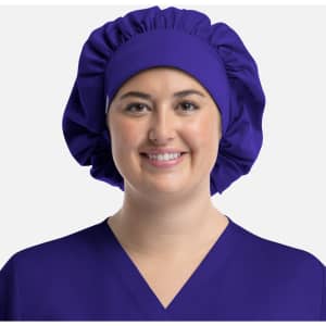 A unisex bouffant cap in purple, worn by a person with a smiling expression, featuring a soft, gathered design.