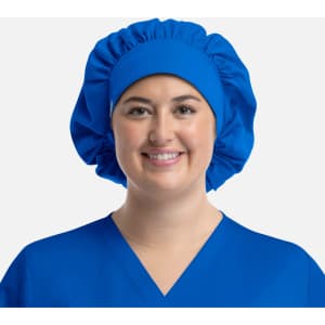 A blue bouffant cap worn by a smiling person, featuring a gathered design for a secure fit.