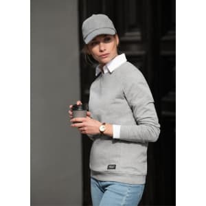 A grey sweatshirt with a round neckline, paired with a white collared shirt and a cap, held with a drink cup.