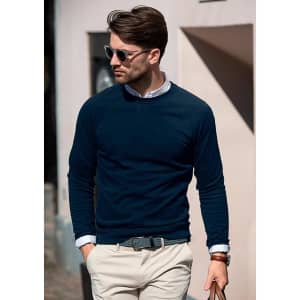 A navy sweatshirt worn by a man, accessorised with sunglasses, walking in a casual outdoor setting.