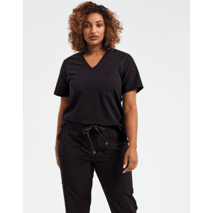 A woman wearing a black tunic with a V-neck and loose sleeves, paired with matching black pants.