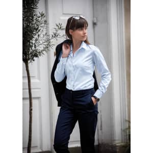 A light blue button-up shirt is displayed, worn by a model alongside navy trousers and a black jacket.