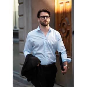 A stylish light blue button-up shirt worn by a man carrying a jacket and a folder, set against an urban backdrop.