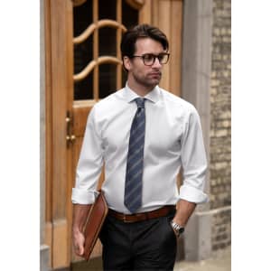 A slim fit white button-up shirt on a man, paired with a striped tie and black trousers, featuring a logo on the shirt.