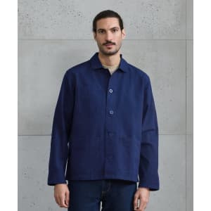 A navy blue chore jacket with a button-up front, featuring a simple design and a logo.
