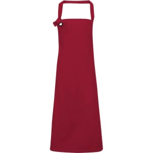 A red heavy cotton canvas bib apron featuring an adjustable neck strap and a logo on the front.