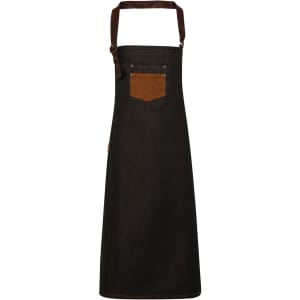 A black denim bib apron with a brown pocket and a strap at the top. Features a small logo on the side.