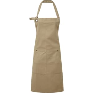 A heavy cotton canvas apron in a khaki colour, featuring multiple pockets and an adjustable strap.