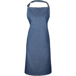 A denim bib apron in a solid blue colour, featuring an adjustable neck strap and a brand logo.