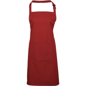 A red bib apron featuring a pocket and an adjustable neck strap. It has a simple design and includes branding.