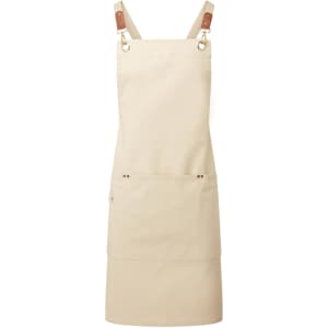 A beige cross-back bib apron featuring adjustable straps and a front pocket, with a logo on the fabric.