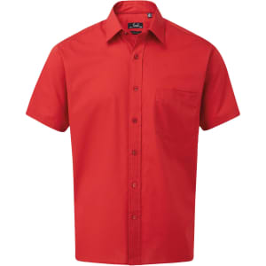 A short-sleeve button-up shirt in bright red, featuring a front pocket and a collar. It has a branding logo.