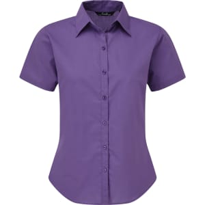 A purple short-sleeved button-up blouse with a collared neckline and a fitted silhouette. The shirt has a logo.