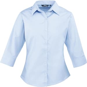 A light blue women's 3/4 sleeve poplin blouse with a button-up front and a collar. It features a logo on the label.