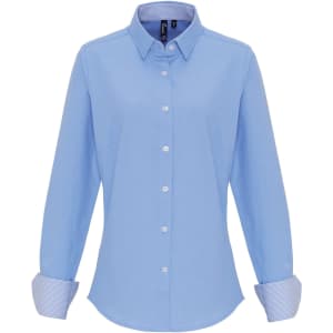 A light blue women's cotton-rich button-up shirt with a classic collar and striped cuffs. Features a logo.
