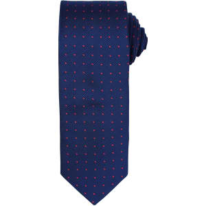 A navy tie featuring small red dots, neatly rolled. The tie includes a branding logo.