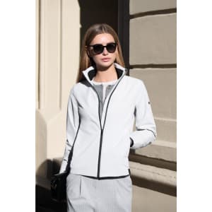 A women's jacket in white with black accents, featuring a zip-up front and a high collar. The model wears sunglasses.