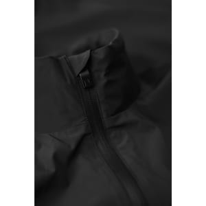 A black jacket featuring a high collar and zip closure, with a minimalist design. It has a logo on the fabric.