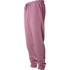 A pair of men's pigment dye sweatpants in a soft mauve colour with pockets and an elastic waistband.