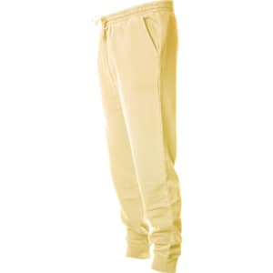 A pair of yellow pigment dye sweatpants with an elastic waistband and side pockets, featuring a logo.