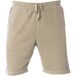 A pair of light beige sweatshorts featuring an elastic waistband and drawstring, with a branding logo on the side.