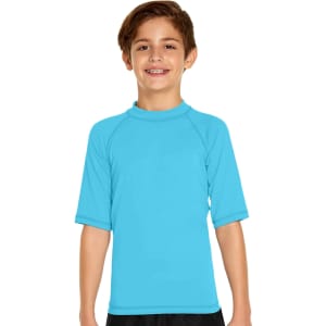 A boy smiles while wearing a bright blue short sleeve rashie with a high collar and raglan sleeves.