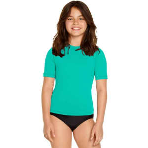 A youth short sleeve rashie in bright turquoise, featuring a logo, worn with black swim bottoms.