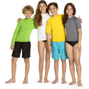 A group of four children wearing youth long sleeve rash guards in green, white, yellow, and grey, along with swim shorts.