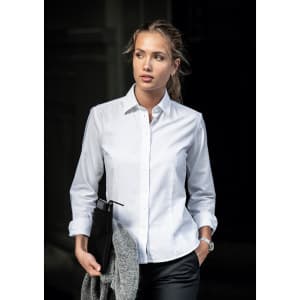 A button-up shirt in white, featuring a collar and rolled-up sleeves, held with a grey blazer and black bag.