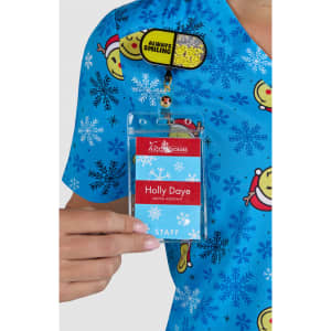 A blue printed top featuring various cartoon characters and snowflakes, with a staff name badge attached.