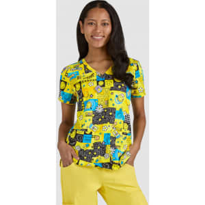 A vibrant yellow top featuring various playful prints, paired with yellow pants, worn by a woman smiling.