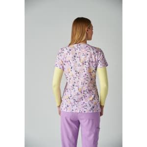 A floral-patterned purple top with short sleeves, worn over a long-sleeved yellow top, with matching purple trousers.